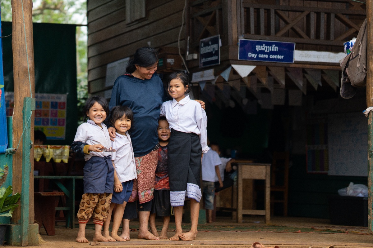 A coffee farmer laughing with her child at a day care